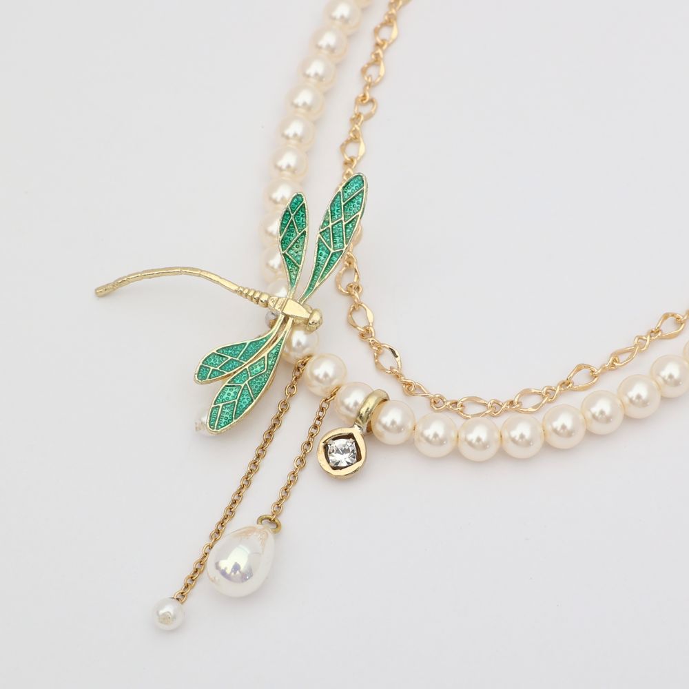 Fly Necklace close-up — handmade brass enamel dragonfly pendant with crystal charm and pearl drops