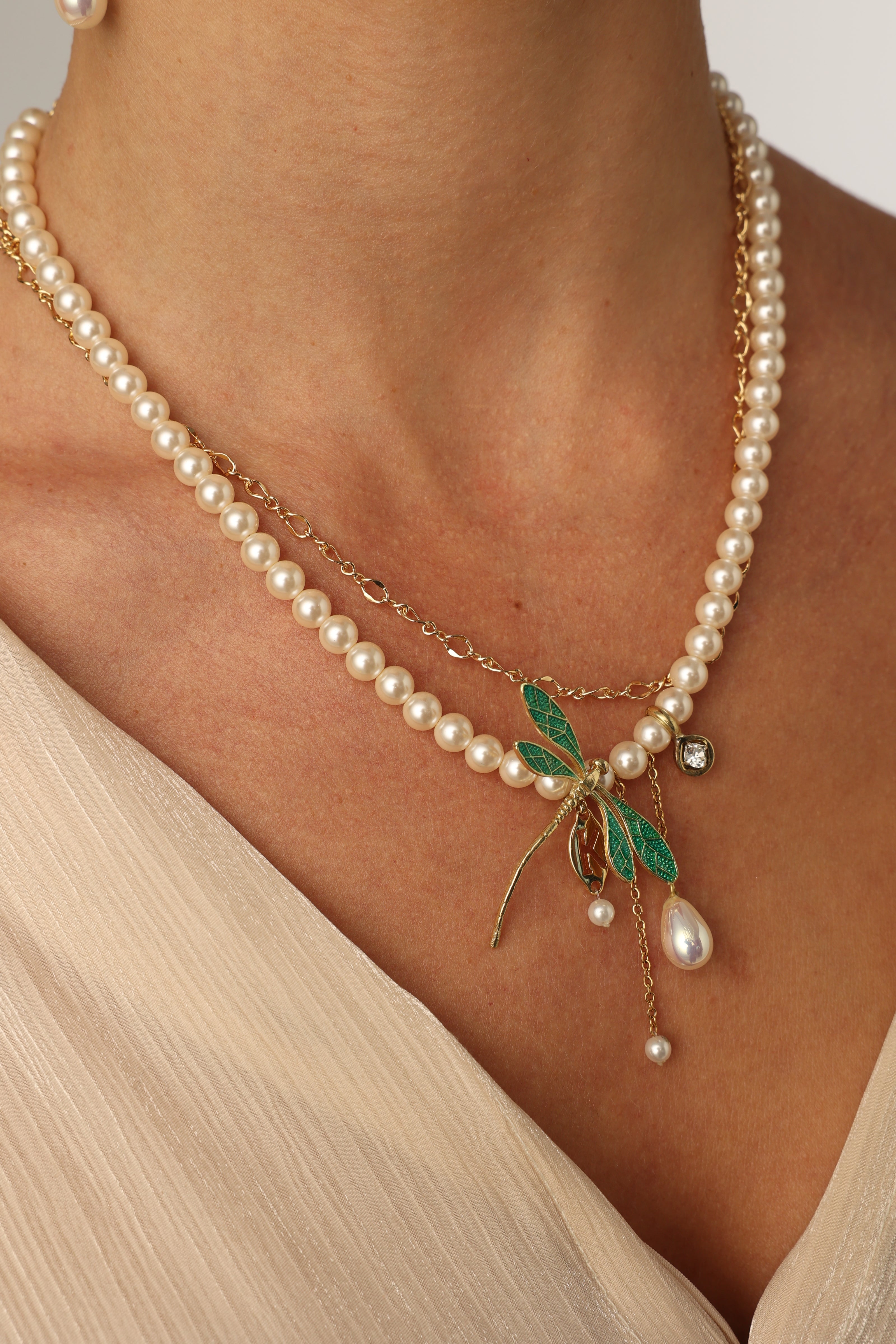 Fly Necklace on model — layered freshwater pearl and brass chain necklace with enamel dragonfly pendant, made in Greece
