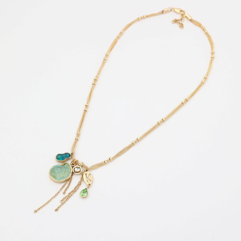 Gold necklace with green pendant on a white background