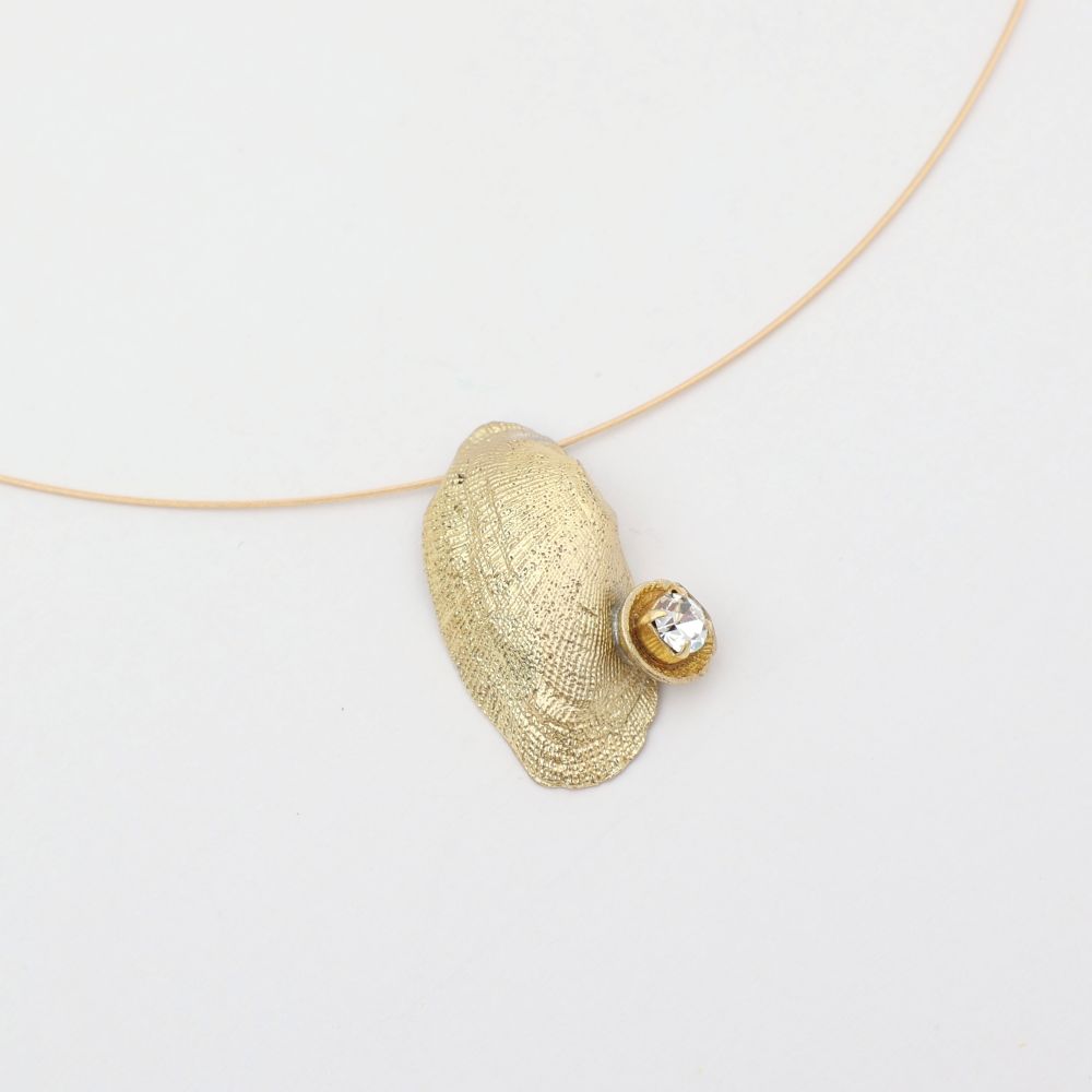 Gold necklace with a shell pendant on a white background