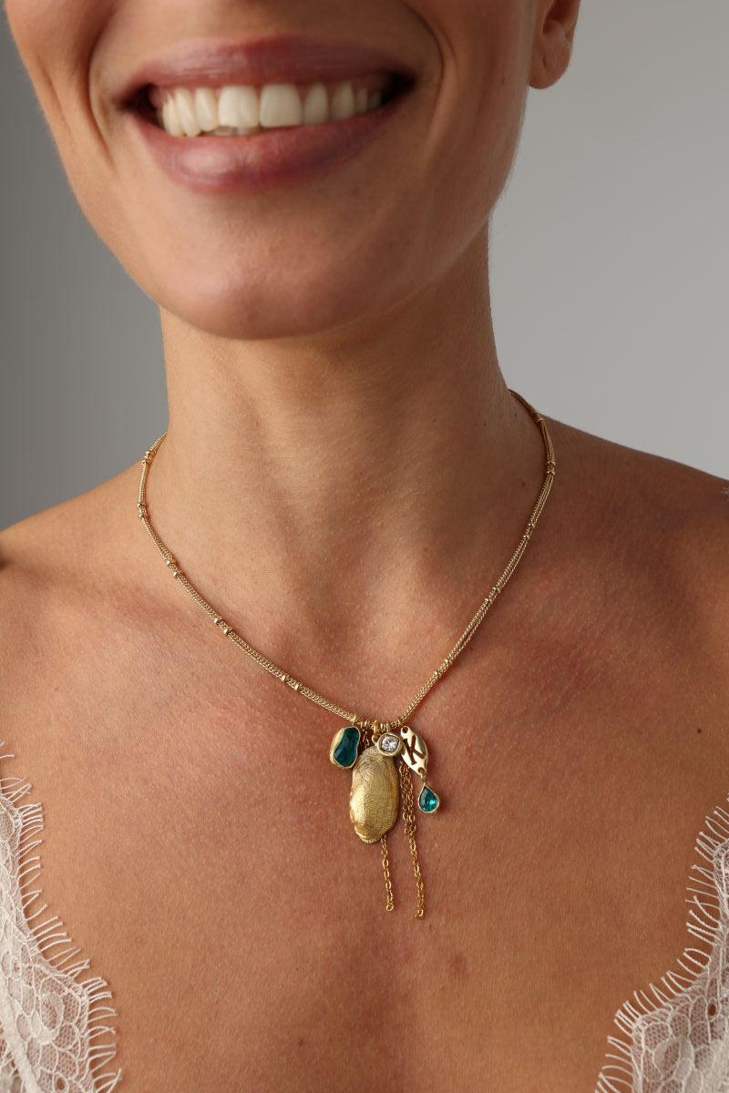 Charmy Limpet Necklace — handmade brass jewelry gemstone charm necklace with sea tokens on model