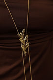 handmade brass leaf and crystal pendant necklace worn long against fabric