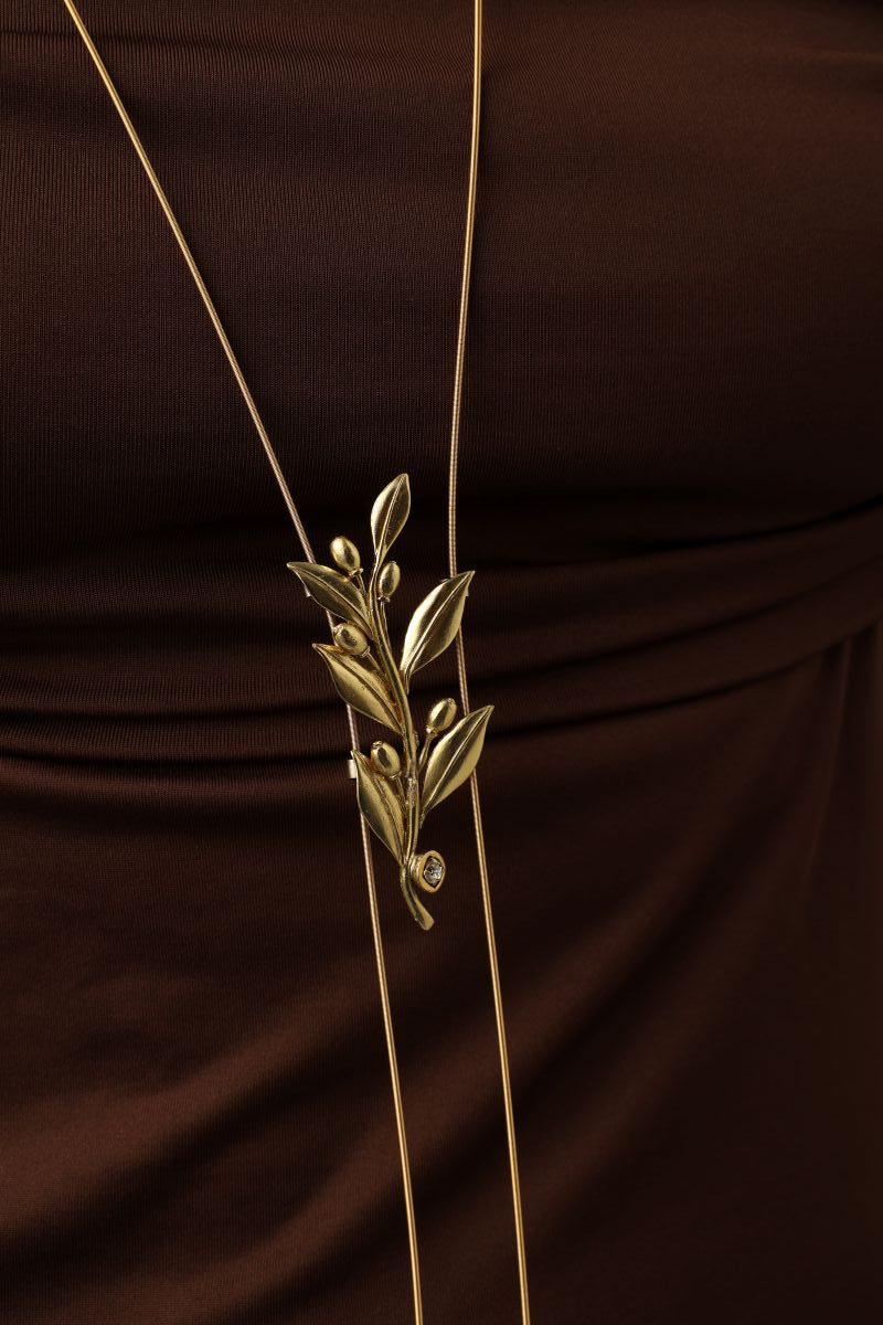 handmade brass leaf and crystal pendant necklace worn long against fabric