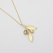 Alea Necklace detail — handmade brass olive branch necklace with crystal fruit and leaf charms
