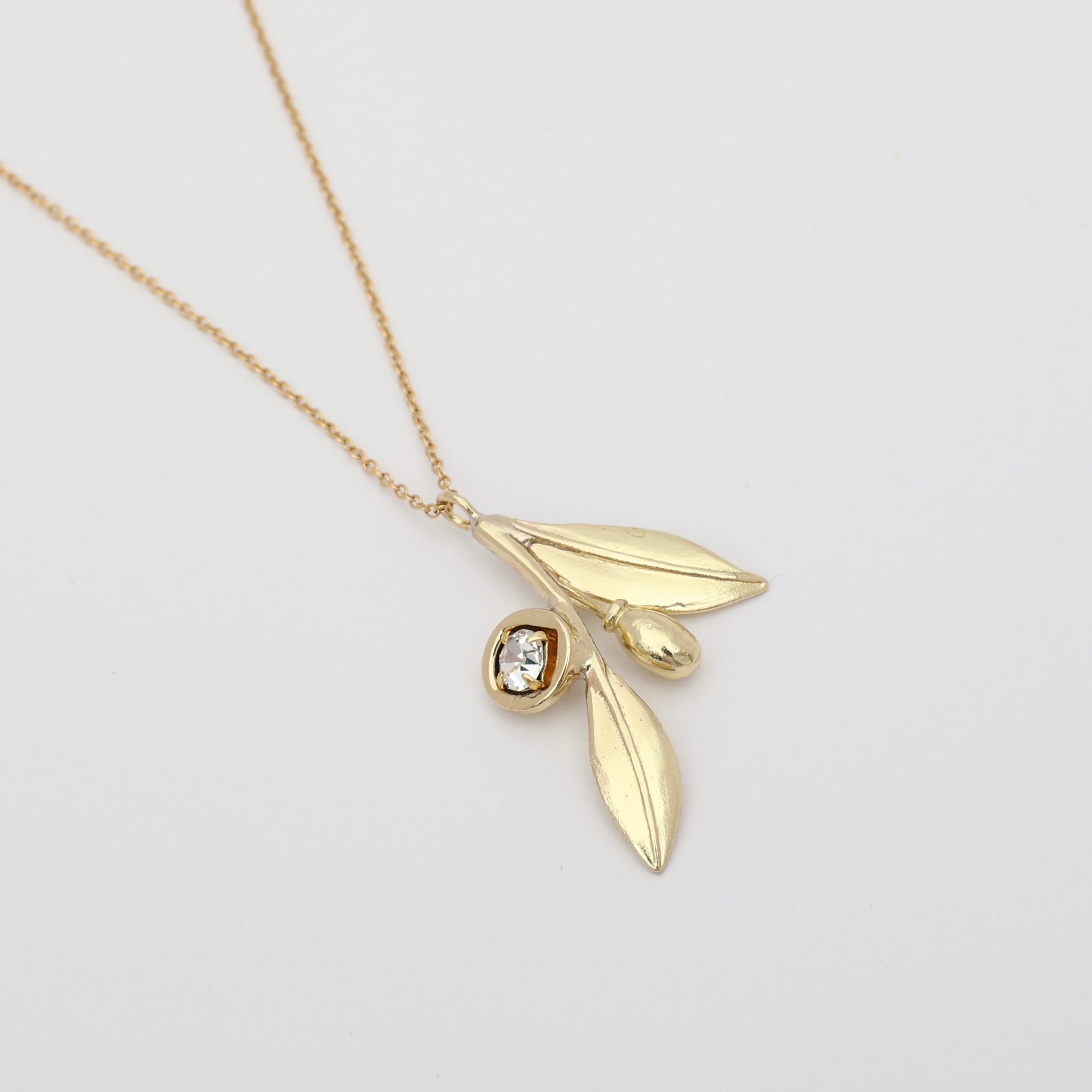 Alea Necklace detail — handmade brass olive branch necklace with crystal fruit and leaf charms
