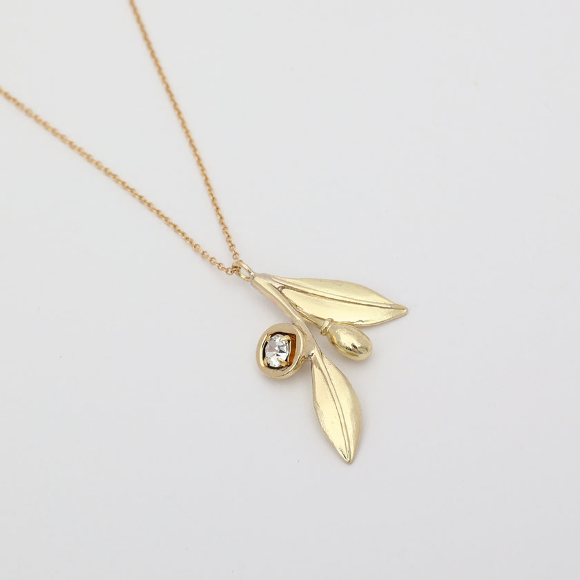 Alea Necklace detail — handmade brass olive branch necklace with crystal fruit and leaf charms
