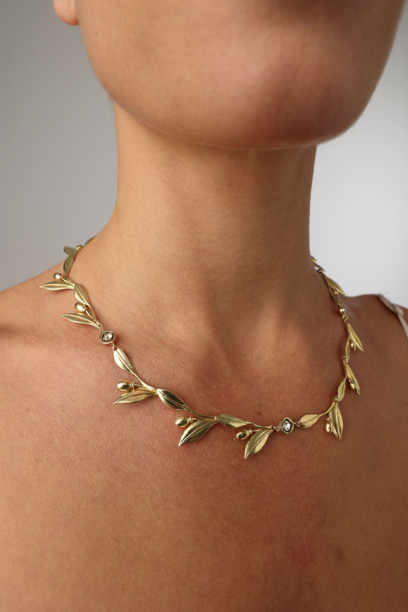 handmade brass statement necklace with sculptural leaf motifs and crystal details
