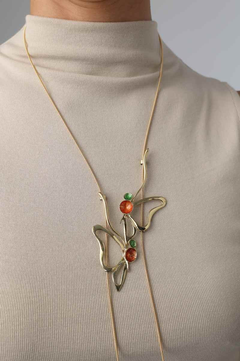 Vela Necklace on model — oversized sculptural brass pendant long necklace, orange and green enamel