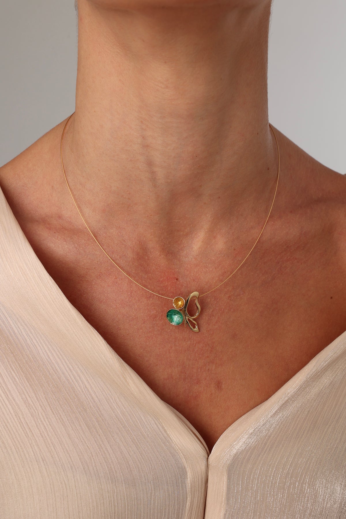Nolia Necklace — handmade brass enamel pendant necklace worn on model, green and yellow