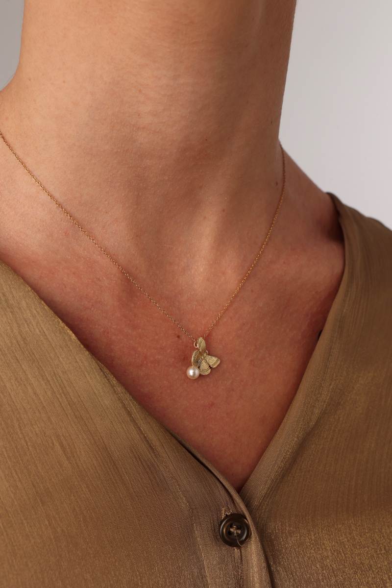 Elys Necklace — handmade brass butterfly pendant necklace with freshwater pearl, worn on model