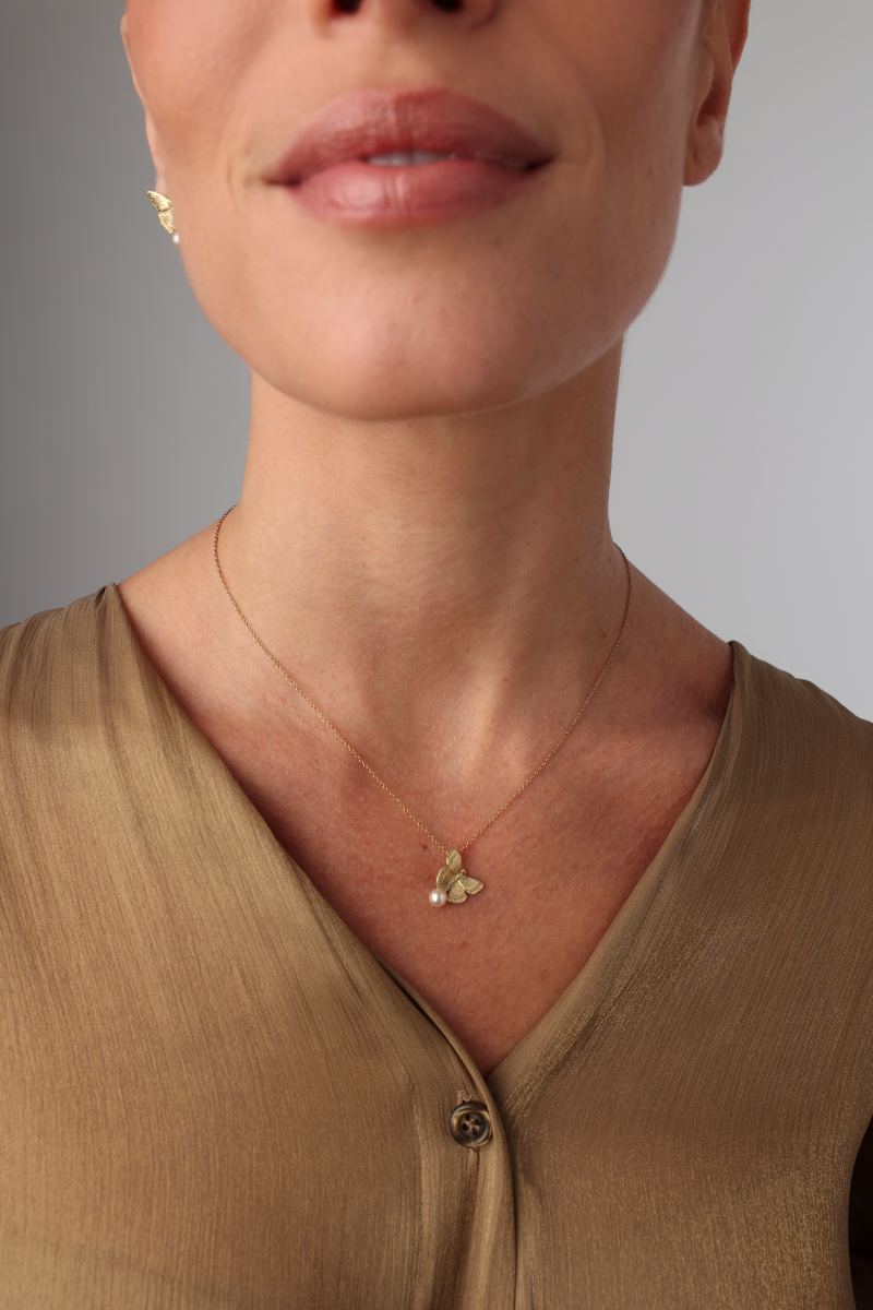 Elys Necklace on model — dainty brass butterfly and pearl pendant necklace on cable chain