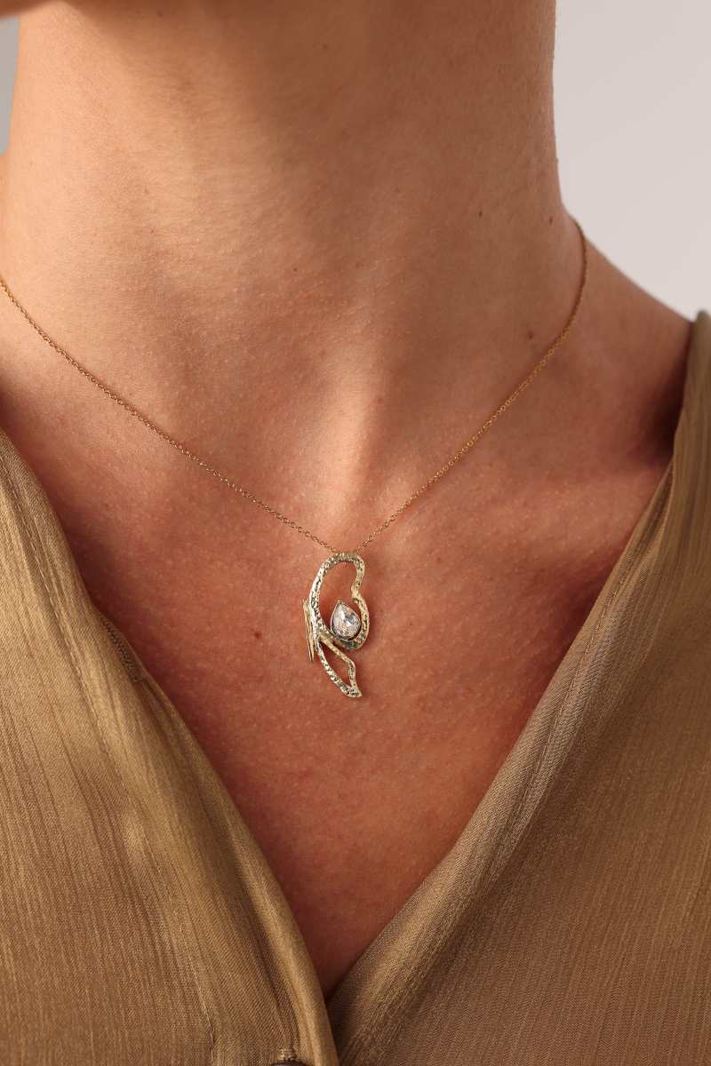 Flutter Necklace — handmade brass sculptural pendant necklace with crystal gemstone, worn on model
