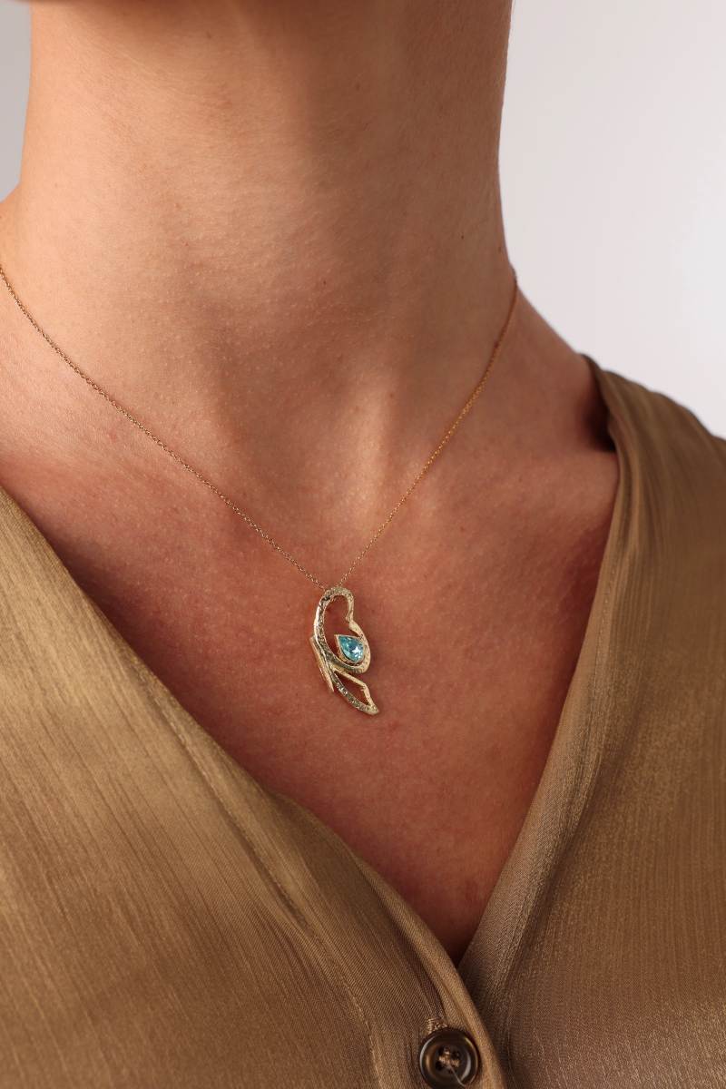 Flutter Necklace on model — handmade brass statement necklace with blue teardrop gemstone