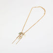 Gold necklace with charms on a light gray background