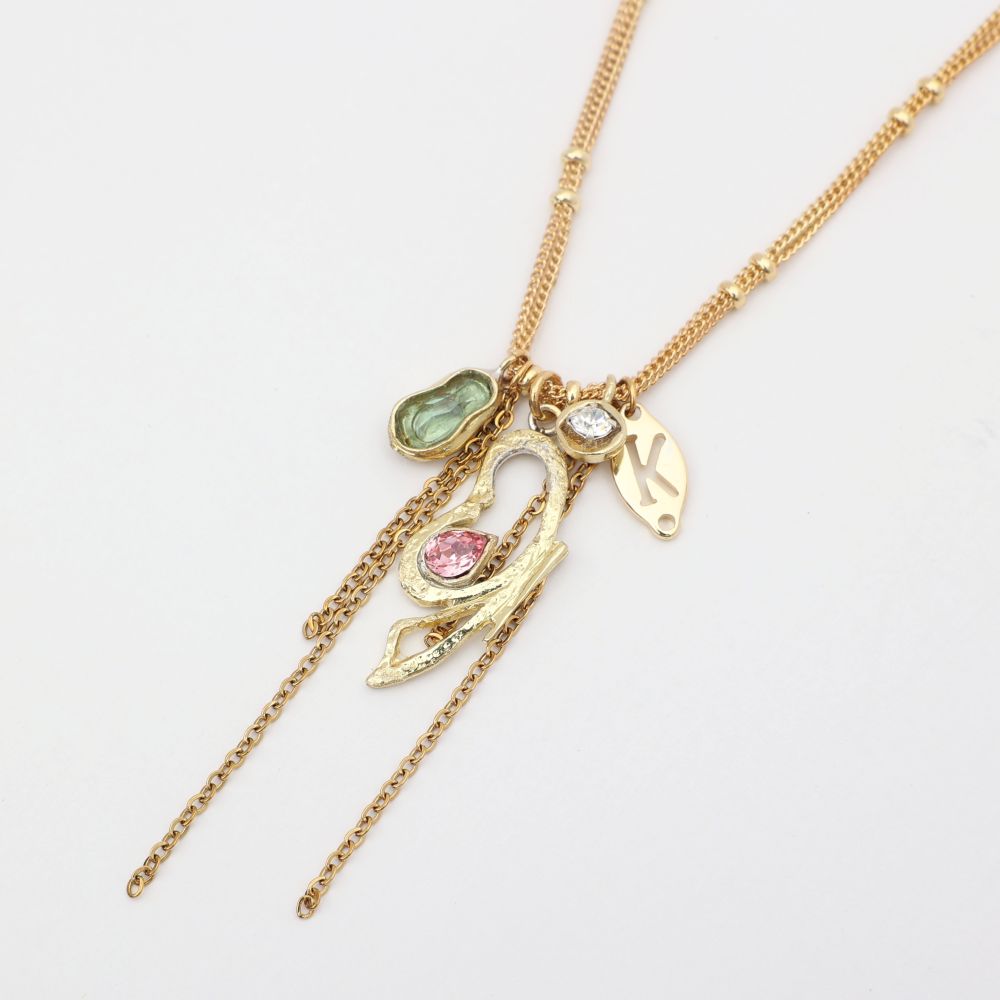 Gold necklace with various charms on a light gray background