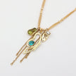 Gold necklace with various charms on a white background