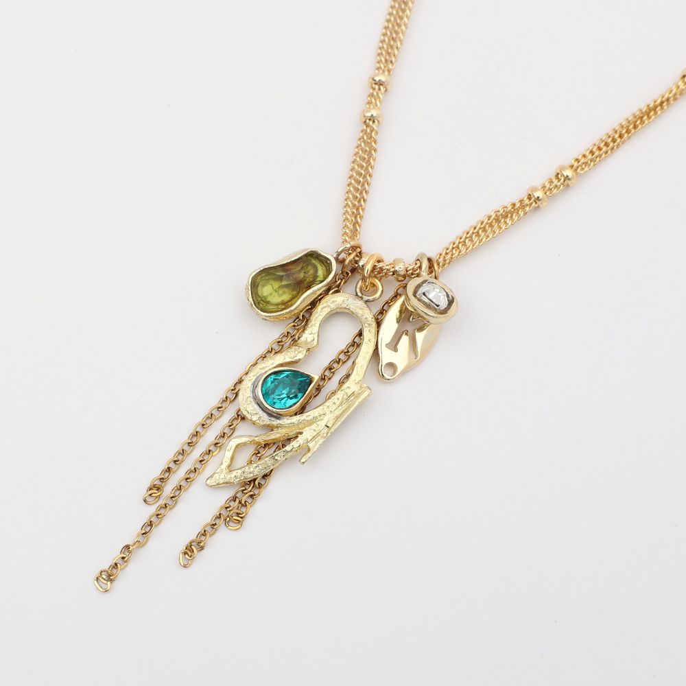Gold necklace with various charms on a white background