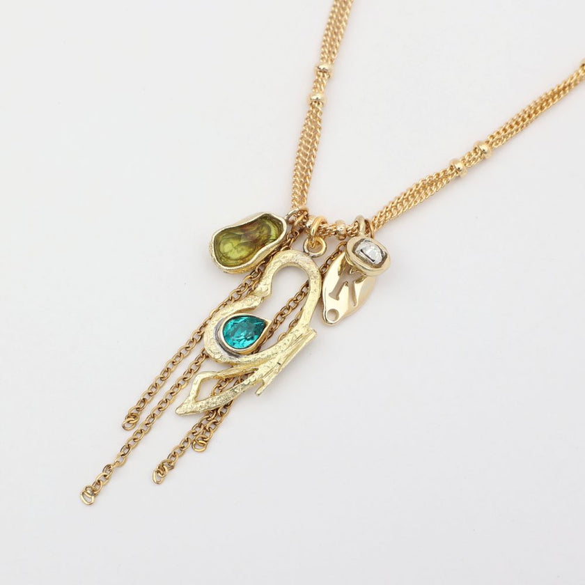 Gold necklace with various charms on a white background