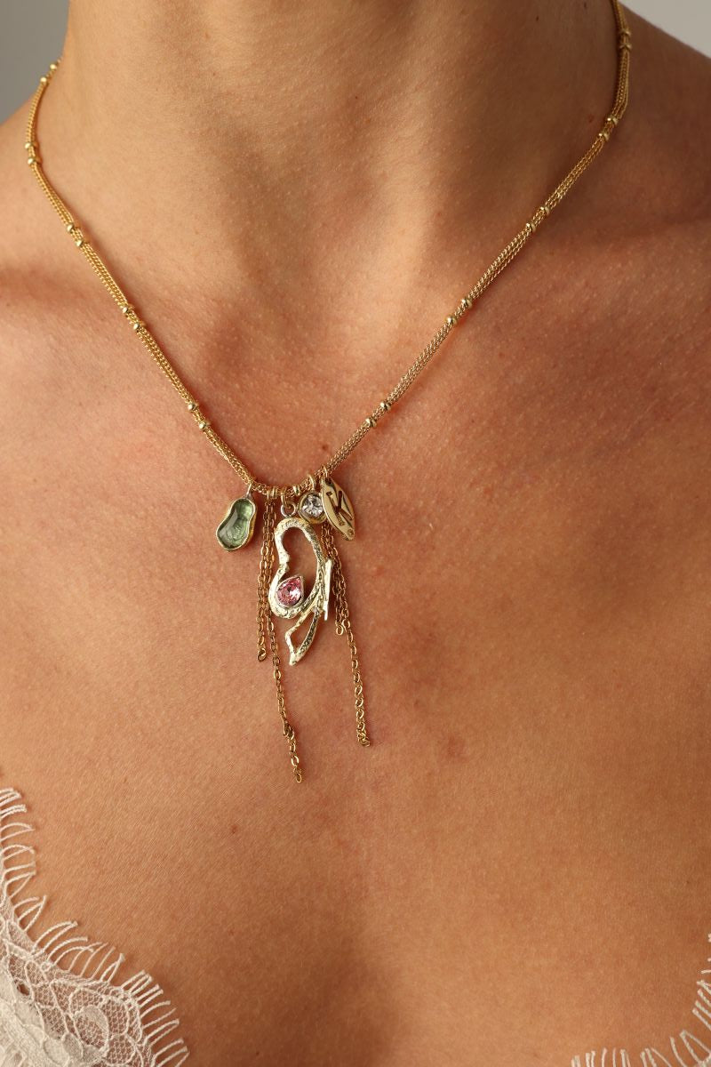 Liora Necklace on model — artisan brass charm necklace with layered gemstone pendants and dangling chains