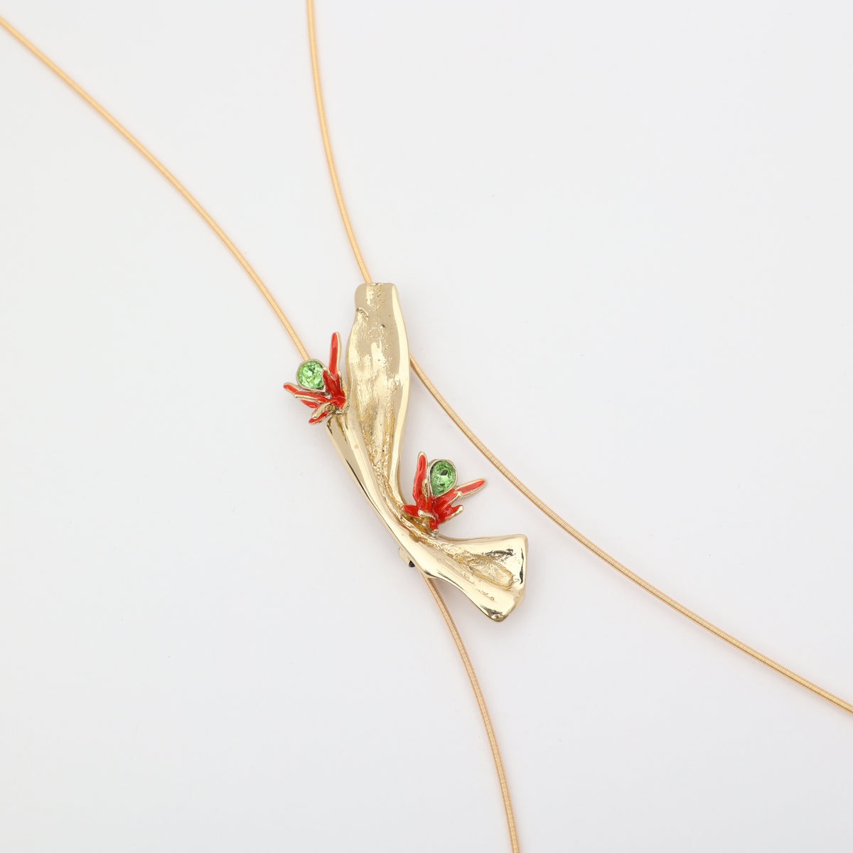 Navily Necklace close-up, handmade brass pendant with red enamel and green crystal, unique Greek statement necklace.