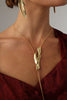 Dragonfish Necklace — handmade brass sculptural lariat necklace with raw pendant on model, styled with matching earrings