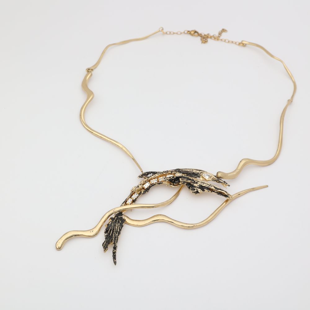 Dragon Necklace — handmade brass sculptural statement necklace with oxidized pendant and baguette crystals, flat lay