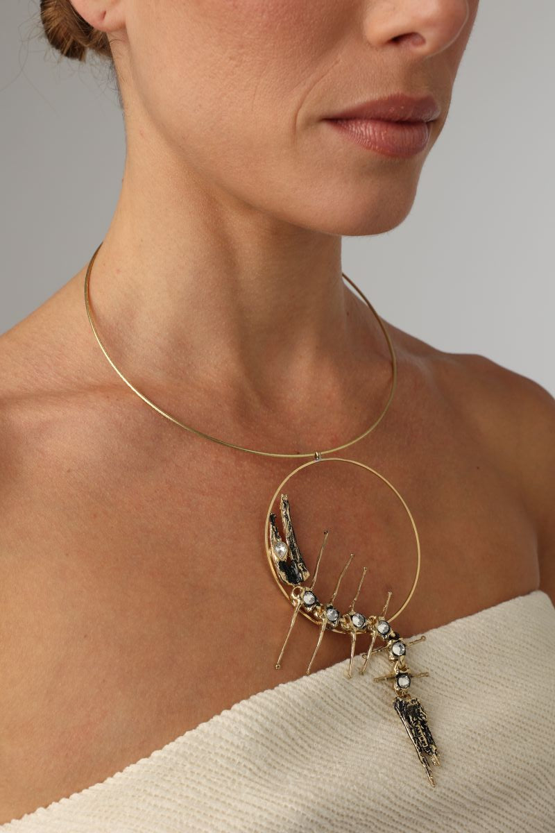 Draco Necklace close-up ,  artisan brass necklace with abstract circular pendant and textured details