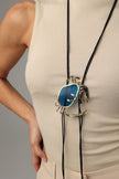 Long Crasta Necklace detail — handmade brass crab necklace with textured claws, crystal baguettes and framed resin stone
