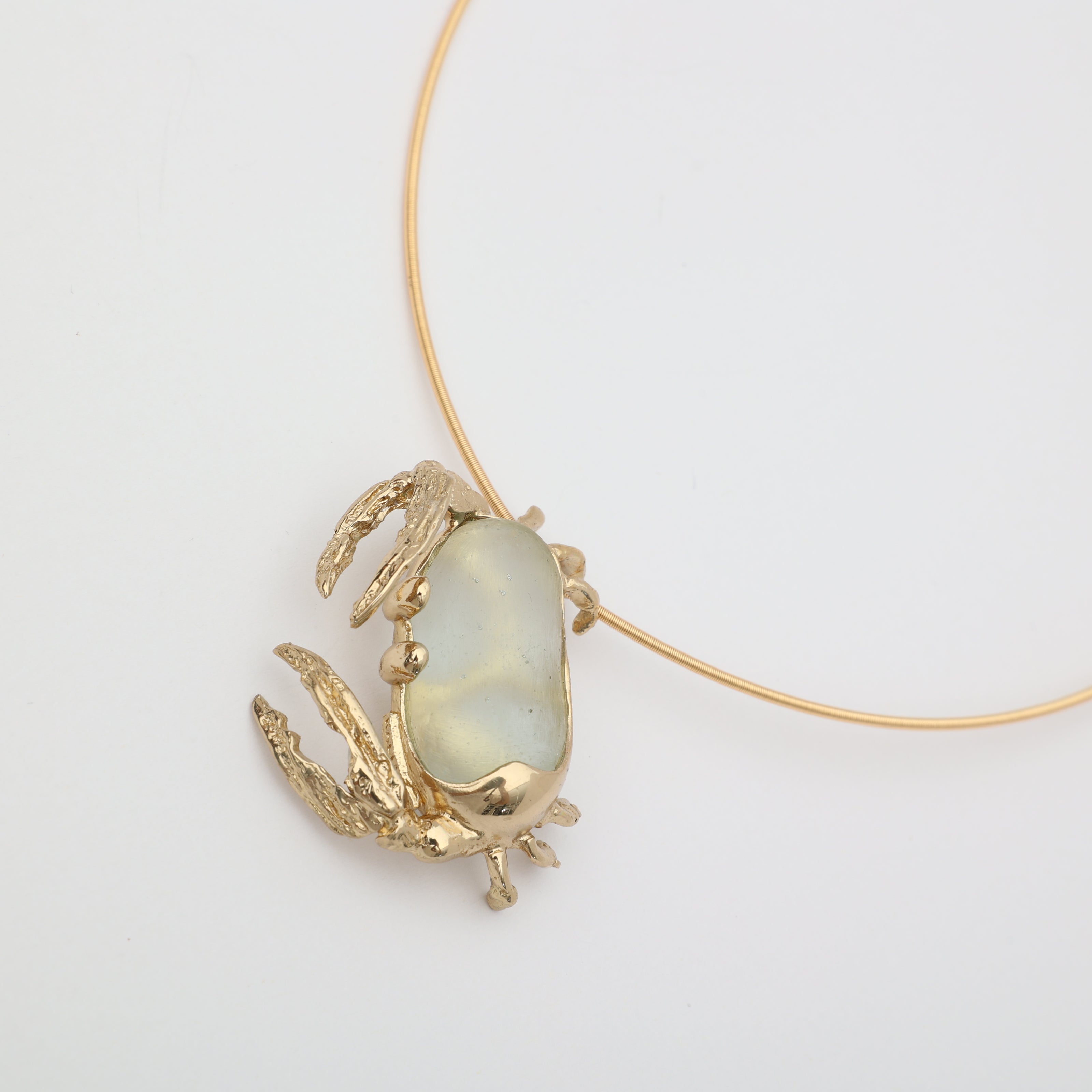 Crabby Necklace close-up — handmade brass crab necklace showing detailed claws and legs around freeform resin stone