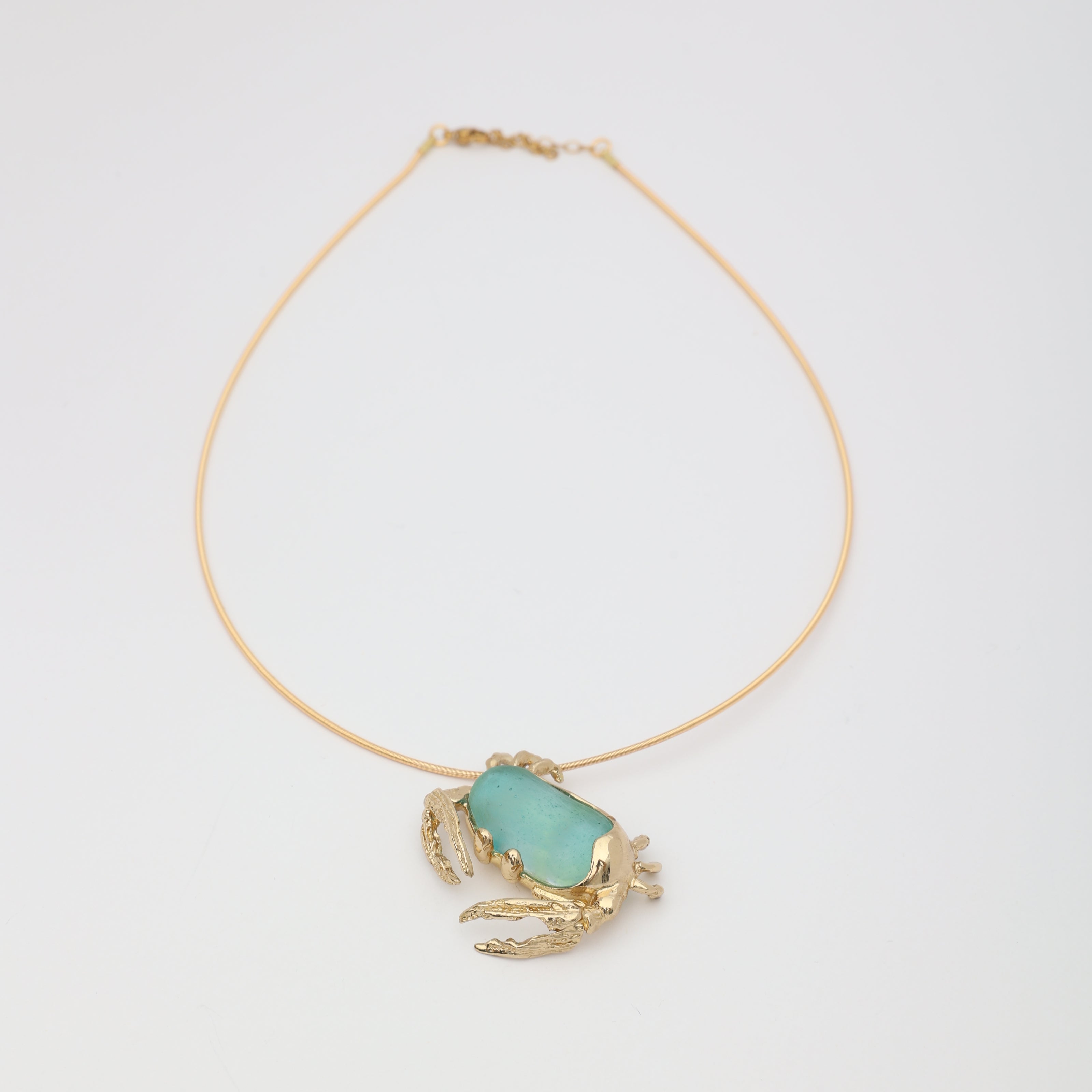 Crabby Necklace — handmade brass crab pendant necklace with large freeform resin stone on white background
