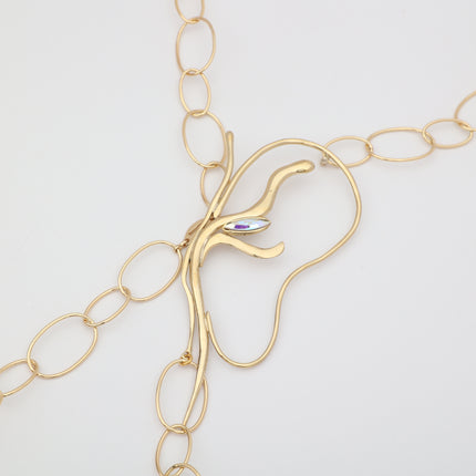 Flat lay close-up of handmade brass abstract pendant with iridescent marquise crystal and oval link chain, unique Greek designer jewelry.