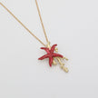 Astel Necklace — handmade brass starfish pendant necklace with enamel finish and coral branch, flat lay