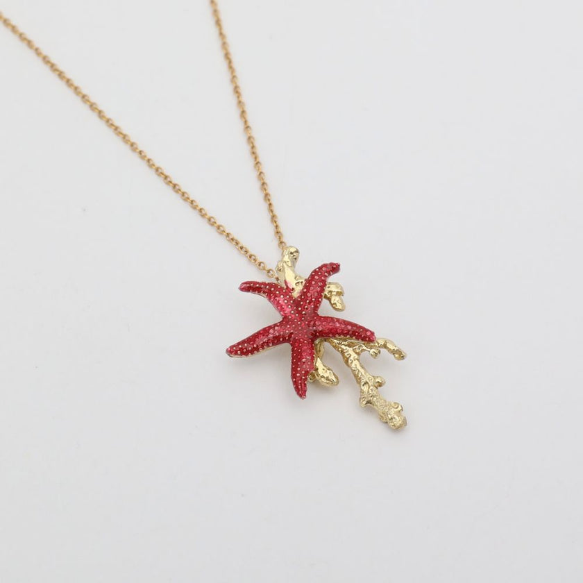 Astel Necklace — handmade brass starfish pendant necklace with enamel finish and coral branch, flat lay