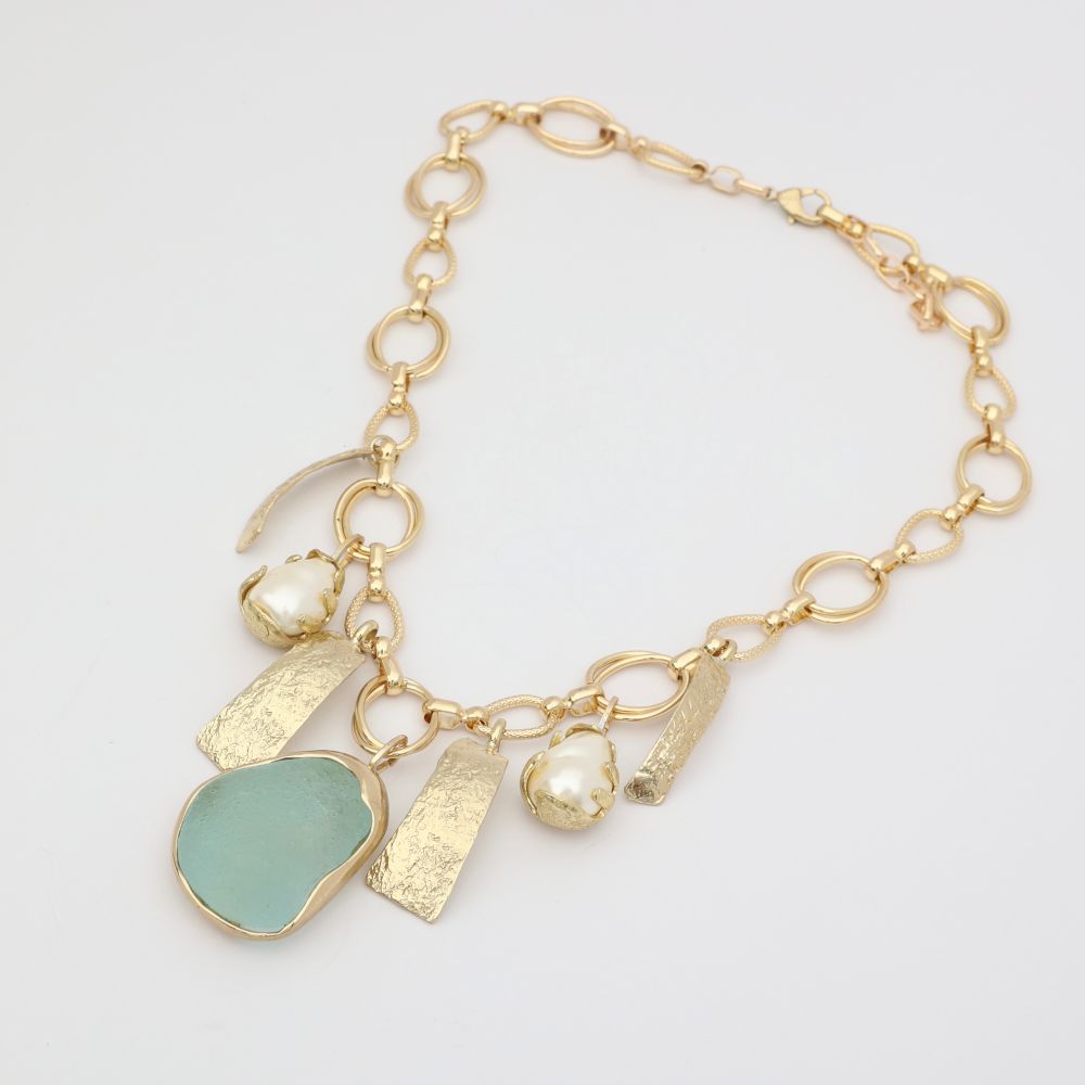Gold bracelet with various charms on a light gray background