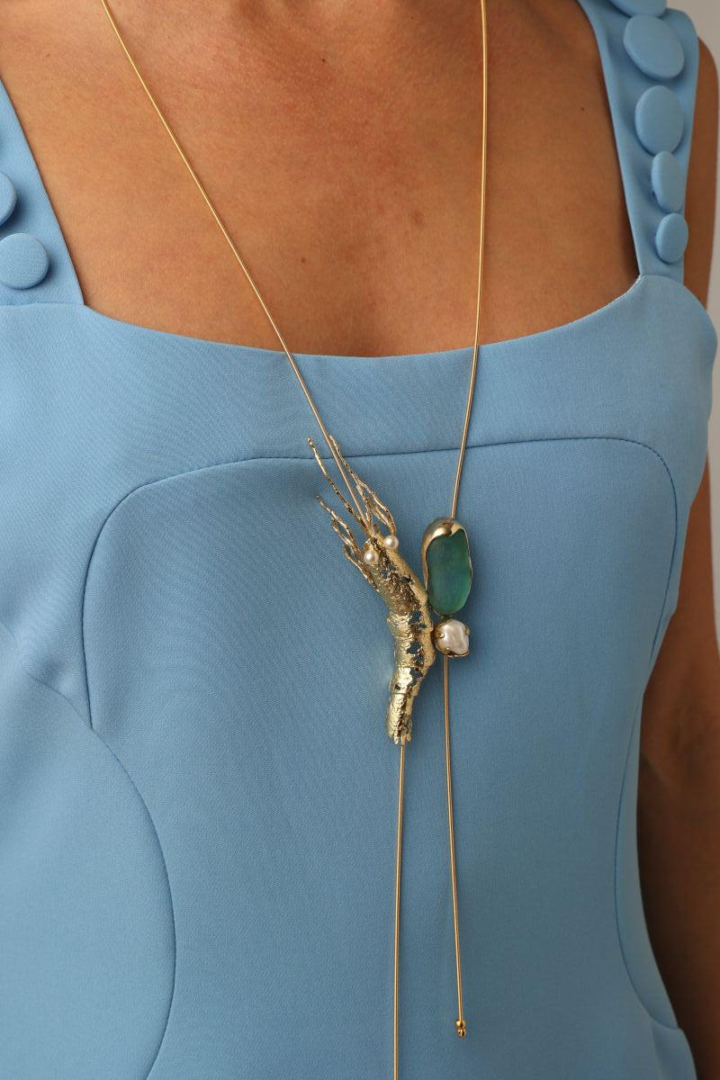 Pebble Shrimp Necklace — handmade brass sculptural shrimp pendant necklace with gemstone and pearl on model, close-up