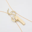 handmade brass wave and Greek column pendant necklace, flat lay close-up front