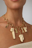  handmade brass Greek sculptural charm necklace on model, décolleté view