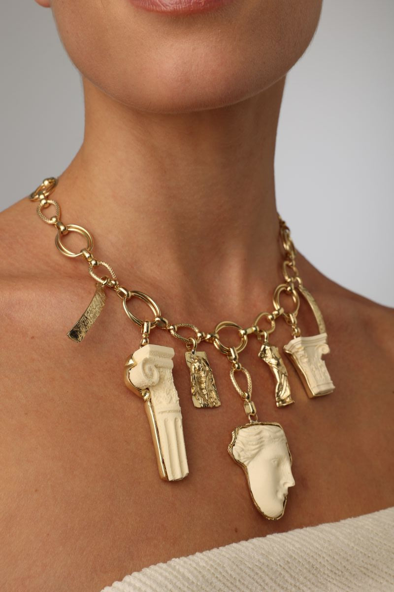  handmade brass Greek sculptural charm necklace on model, décolleté view