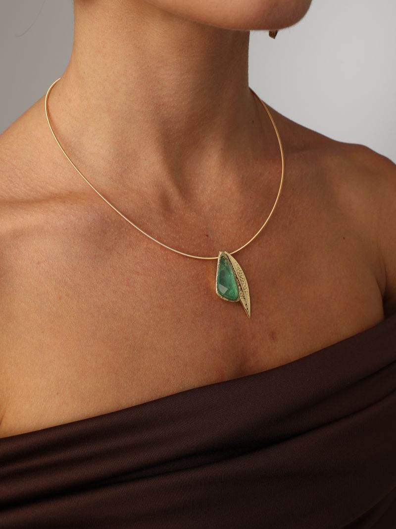 Handmade brass rigid collar necklace with leaf pendant and resin stone worn on model
