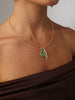 Handmade brass rigid collar necklace with leaf pendant and resin stone worn on model
