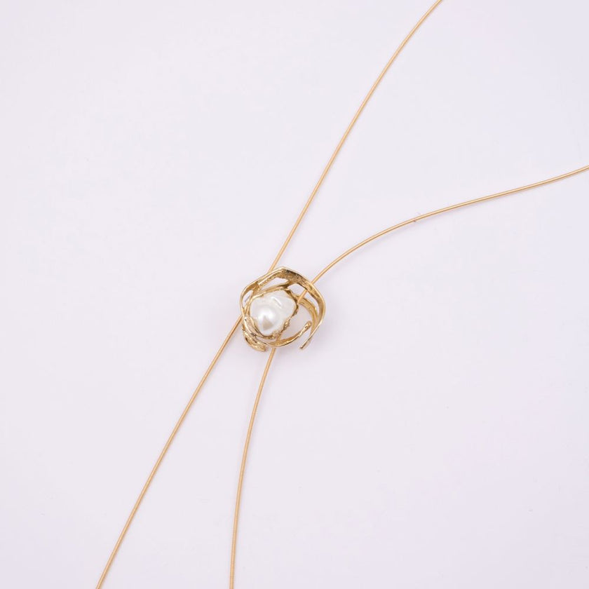 Brass wire necklace with pearl nest pendant detail, close-up, Bubblegum