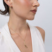 Model wearing the Glade gold pendant necklace with matching leaf-shaped drop earrings, Savage Flora
