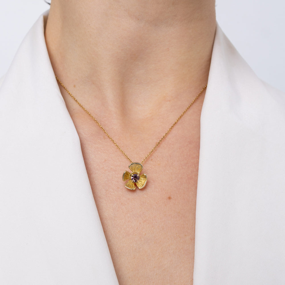 Handmade brass flower pendant necklace with amethyst crystal center, worn, Posy
