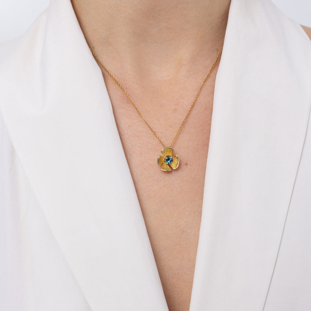 Brass flower pendant necklace with blue topaz crystal center