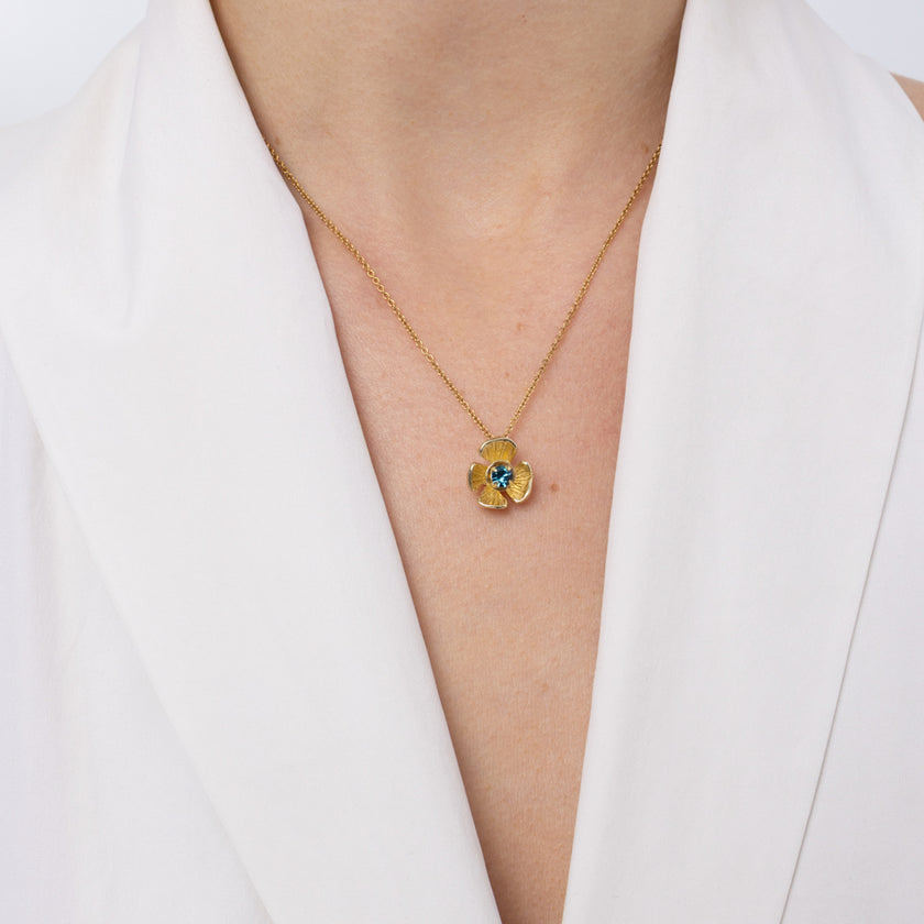 Brass flower pendant necklace with blue topaz crystal center