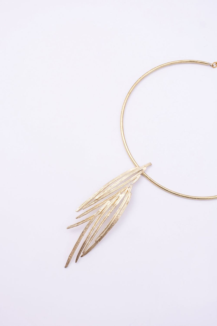 Pine handmade gold-plated brass choker necklace with layered pine-needle pendant on a white background