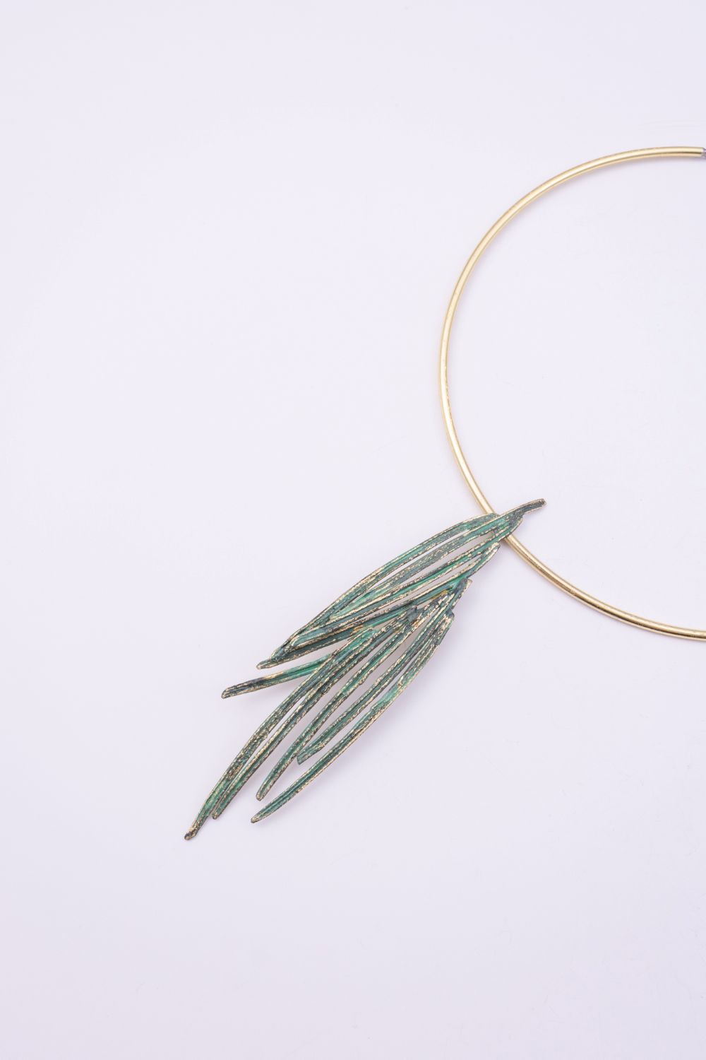 Pine handmade gold-plated brass choker necklace with green patina pendant on a white background