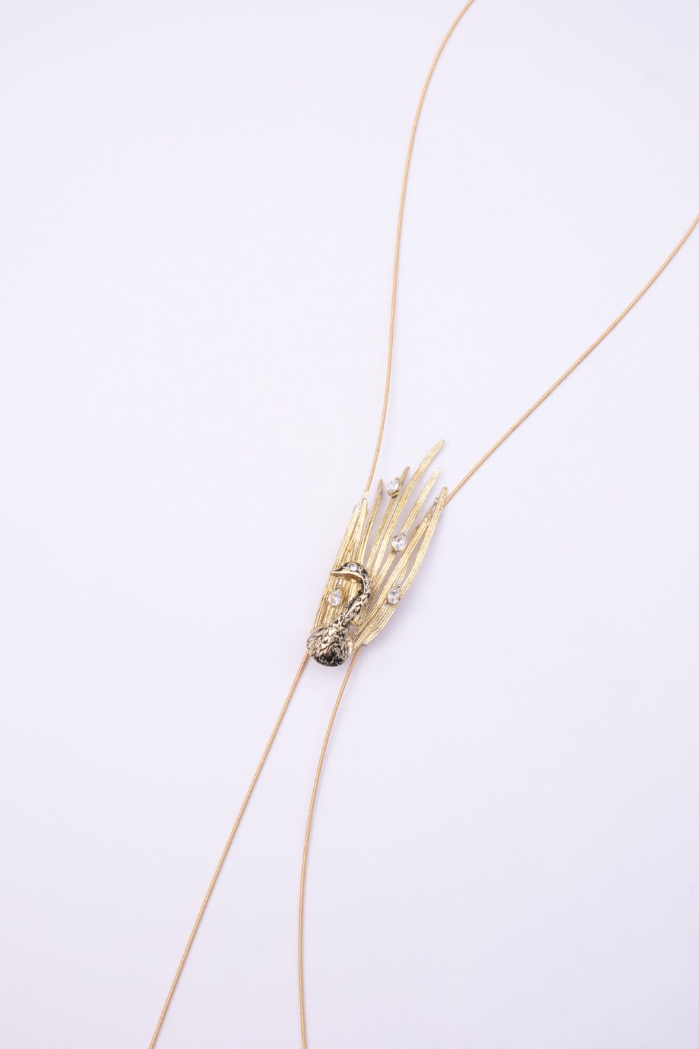 Peacock handmade gold-plated brass long necklace with black oxidized peacock and clear crystal feather tips on a white background