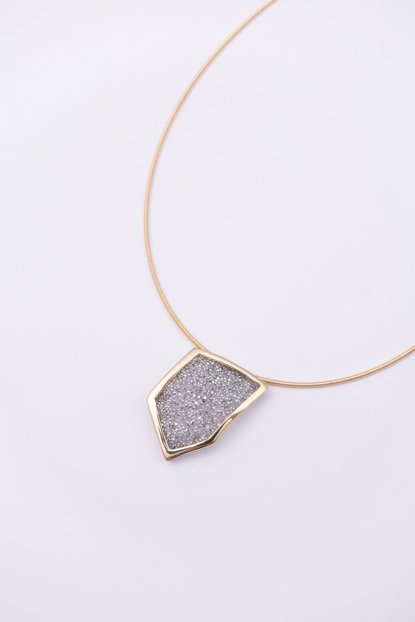 Sparkle Necklace close up: handmade brass pendant with tiny faceted crystals set in a sleek brass frame