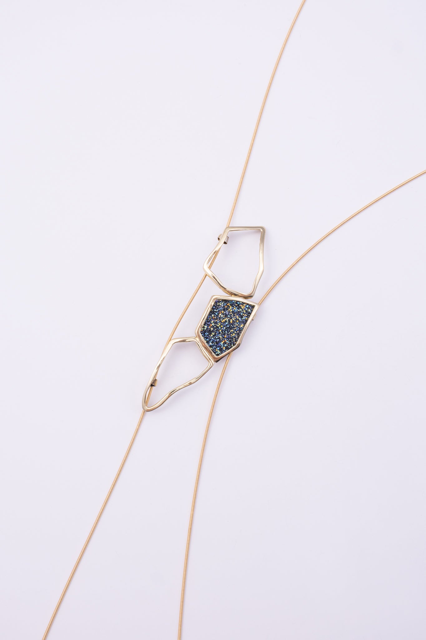Glow Long Necklace on white background: handmade brass long necklace with crystal shard and open loops on slim coiled cord